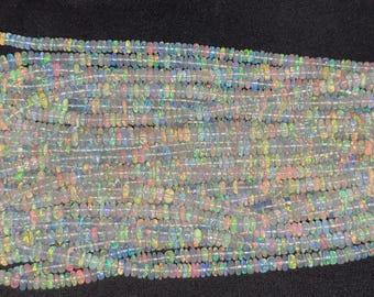 May include: A strand of iridescent white opal beads, each bead is a slightly different shape and size. The beads are strung on a clear thread and are ready to be used for jewelry making.