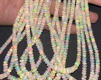 May include: A strand of white opal beads with iridescent rainbow colors. The beads are faceted and have a smooth, polished finish. The strand is approximately 18 inches long.
