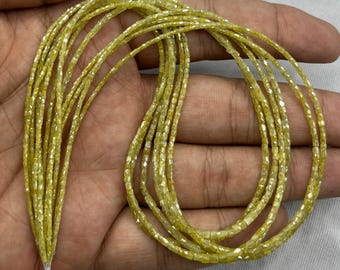 May include: A collection of strands of yellow-toned, faceted beads. The beads are small and square-shaped, strung together to create multiple strands. The beads have a subtle sparkle, and the overall appearance is delicate and elegant.