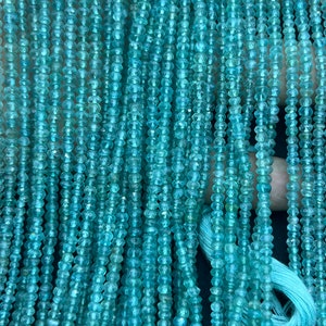 May include: A strand of light blue gemstone beads, each bead is faceted and has a slightly irregular shape. The beads are strung on a thin thread and are ready to be used for jewelry making.