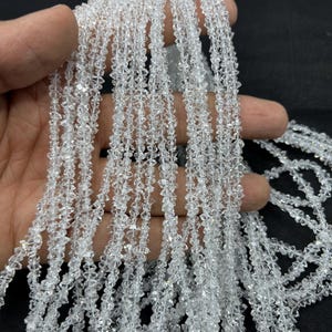 Pode incluir: Um fio de contas de cristal de quartzo transparente, cada conta é facetada e tem uma forma pontiaguda. As contas são enfiadas em um fio transparente e têm aproximadamente 4 mm de tamanho.