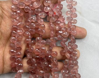 May include: Strands of faceted, teardrop-shaped beads in a soft, dusty rose colour. The beads are strung together, creating a delicate and elegant appearance. The beads are likely made of a gemstone or crystal.