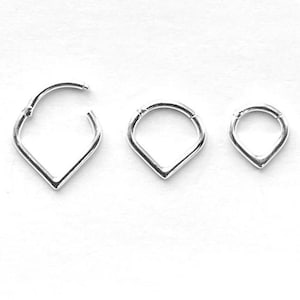 May include: Three silver teardrop-shaped hoop earrings of different sizes.