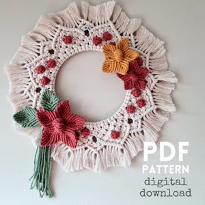 May include: A cream-coloured macrame wreath with a circular design and fringed edges. It is decorated with red, orange, and green floral accents. The text "PDF PATTERN digital download" is visible on the image.