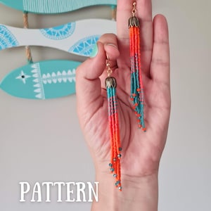 Può includere: Un paio di lunghi orecchini a perline con un design a nappina. Gli orecchini sono realizzati con perline arancioni e turchesi e hanno una parte superiore in metallo dorato.