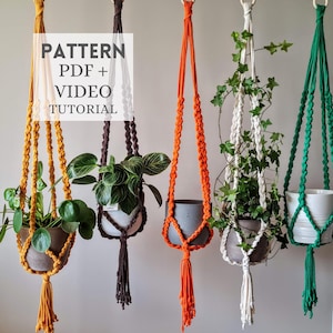 Può includere: Portavasi in macramè di vari colori, tra cui giallo, marrone, arancione, bianco e verde. Ogni portavaso contiene una pianta in vaso. L'immagine include il testo "PATTERN PDF + VIDEO TUTORIAL".
