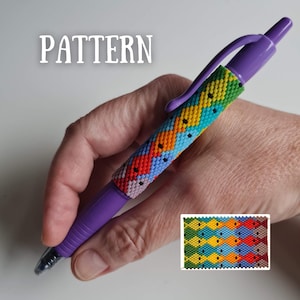 May include: A purple pen with a beaded sleeve featuring a colorful geometric pattern. The pattern includes red, orange, yellow, blue, and green beads. The word "PATTERN" is displayed in white text.