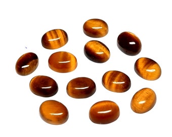 Könnte beinhalten: Eine Sammlung von 14 ovalen Tigeraugen-Edelsteinen. Die Steine sind eine Mischung aus braunen und goldenen Farben mit einem schimmernden Effekt.