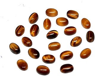 Könnte beinhalten: Eine Sammlung von 20 ovalen Tigeraugen-Edelsteinen. Die Steine sind in einer Mischung aus braunen und goldenen Farben mit einem schimmernden Effekt.