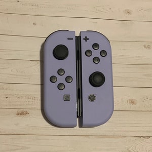 May include: A purple Nintendo Switch Joy-Con controller with black buttons.