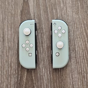 May include: A pair of light blue Nintendo Switch Joy-Con controllers with white buttons.