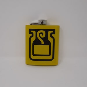 May include: A yellow flask with a black graphic design. The flask has a rectangular shape with rounded corners and a silver cap. The graphic is a stylized design of a bottle or container.