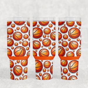 May include: Three clear plastic tumblers with orange lids and straws. Each tumbler features a white background with a repeating pattern of orange basketballs.