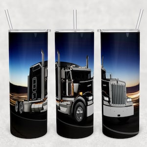Puede incluir: Un camión semi-remolque negro y plateado con un fondo de puesta de sol azul y naranja. El camión conduce por una autopista con luces en el fondo. La imagen está envuelta alrededor de un vaso de acero inoxidable.