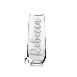 May include: A clear glass champagne flute with the name "Rebecca" etched on the side.
