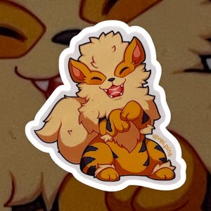 Op de afbeelding: Een sticker met een cartoonillustratie van een glimlachende, oranje-bruine, harige creatuur met een lange staart. Het wezen staat op zijn achterpoten met zijn poten omhoog. De sticker heeft een witte rand en de tekst "@rei.pins" in de rechterbenedenhoek.