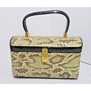 May include: A vintage, snakeskin handbag with a black patent leather top and gold-tone hardware. The handbag has a top handle and a hinged closure.
