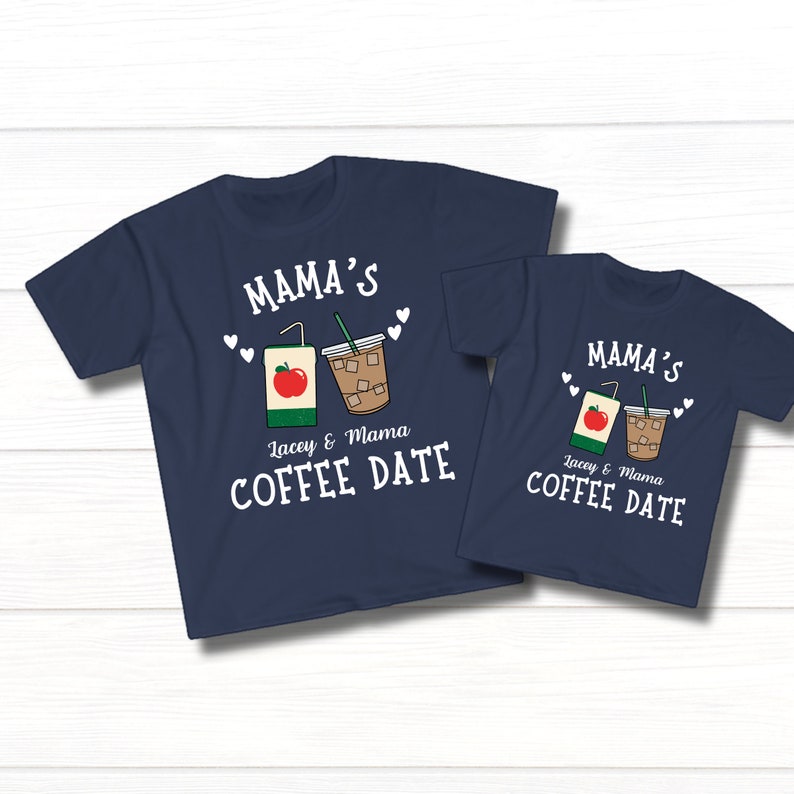May include: Two navy blue t-shirts with a white graphic of a juice box and a cup of iced coffee. The text on the shirts reads "Mama's Lacey & Mama Coffee Date".