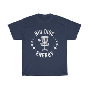 Puede incluir: Camiseta azul marino con un gr&aacute;fico blanco de una canasta de disco de golf y el texto "BIG DISC ENERGY".