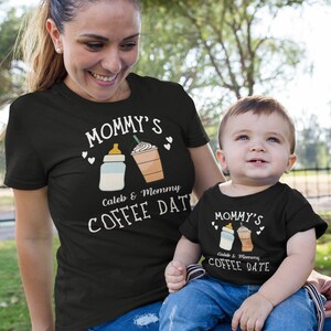 May include: Matching black t-shirts for a parent and child. The adult shirt says "Mommy's Caleb & Mommy Coffee Date" with a baby bottle and a coffee cup graphic. The child's shirt says "Mommy's Caleb & Mommy Coffee Date" with a baby bottle and a coffee cup graphic.
