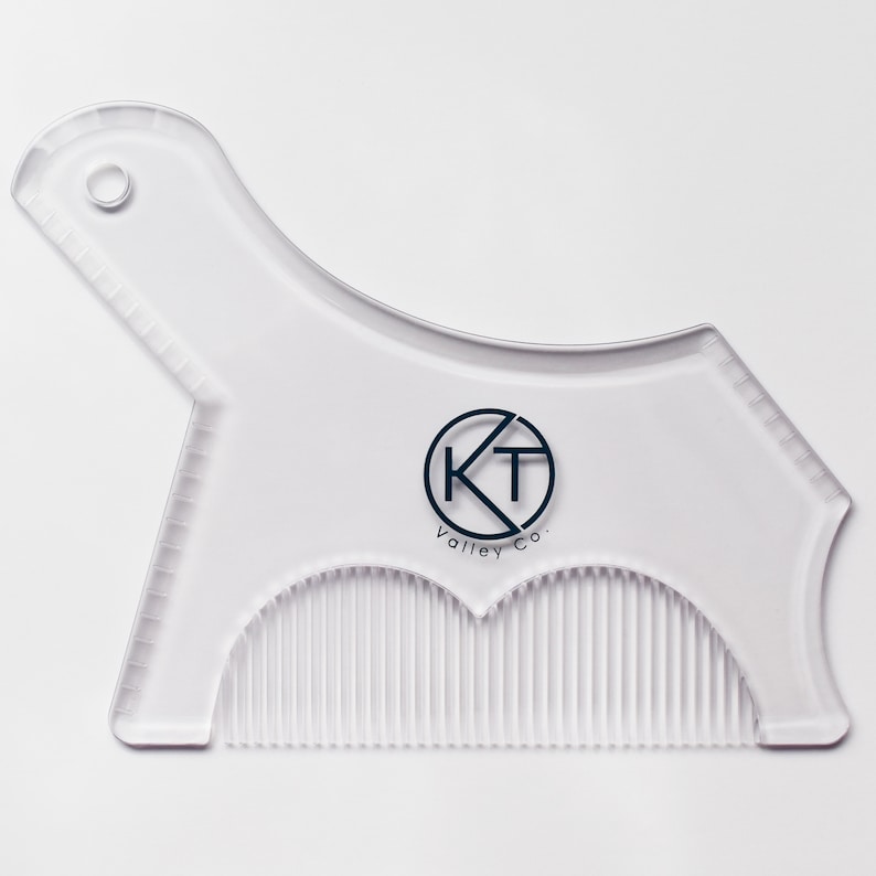 May include: A clear plastic beard shaping tool with a comb on the bottom and a guide on the top. The tool has a circle with the letters KT and the text "Valley Co." printed on it.