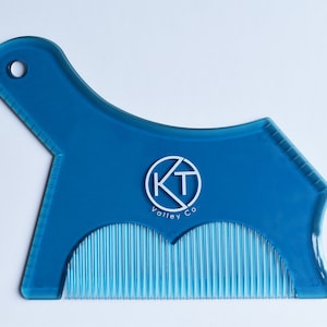 May include: A blue plastic beard trimming tool with a comb on the bottom and a circle logo that says "KT Valley Co."
