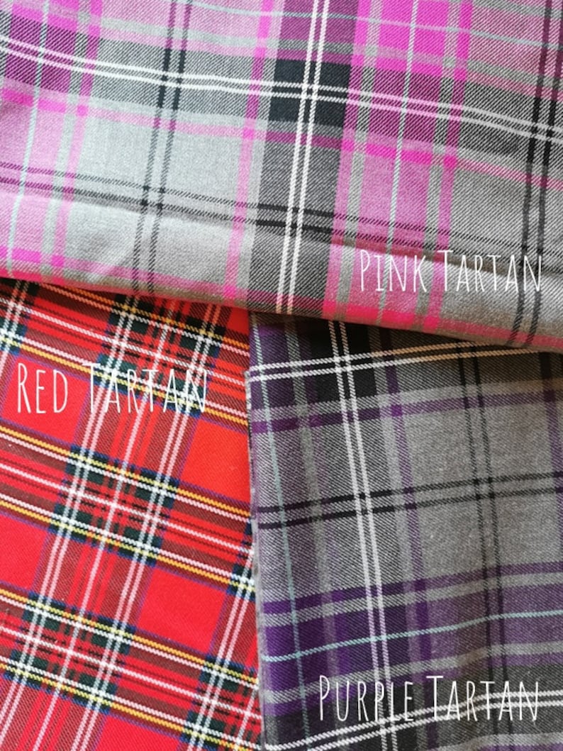 Three different tartan fabrics, one pink, one red, and one purple. The fabrics are folded over each other, with the pink fabric on top, the red fabric in the middle, and the purple fabric on the bottom. The fabrics are all patterned with a traditional tartan design.