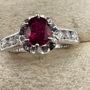 18kt white gold ring with oval cut ruby in the center and brilliant cut diamonds
