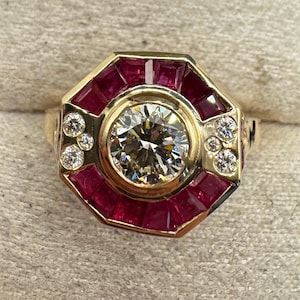18kt yellow gold ring with taiper-cut rubies and brilliant-cut natural diamonds. 1.00 ct center diamond.