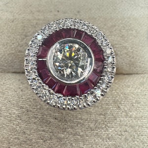 18kt white gold ring with brilliant-cut natural diamonds and princess-cut rubies. 1.00 ct center diamond.