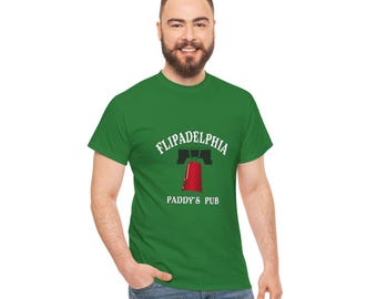 May include: A green t-shirt with a white graphic of a red bell with the text "FLIPADELPHIA PADDY'S PUB" on it.
