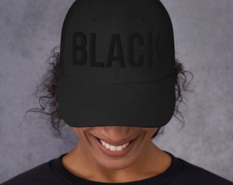 May include: A black baseball cap with the word "BLACK" embroidered in black on the front.