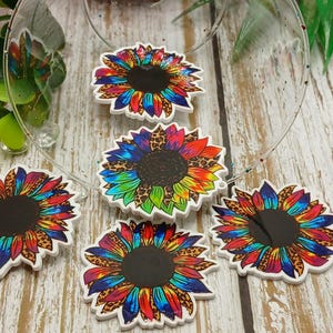 May include: Six colorful tie-dye sunflower resin cabochons with a leopard print design. The cabochons are approximately 1.5 inches in diameter.