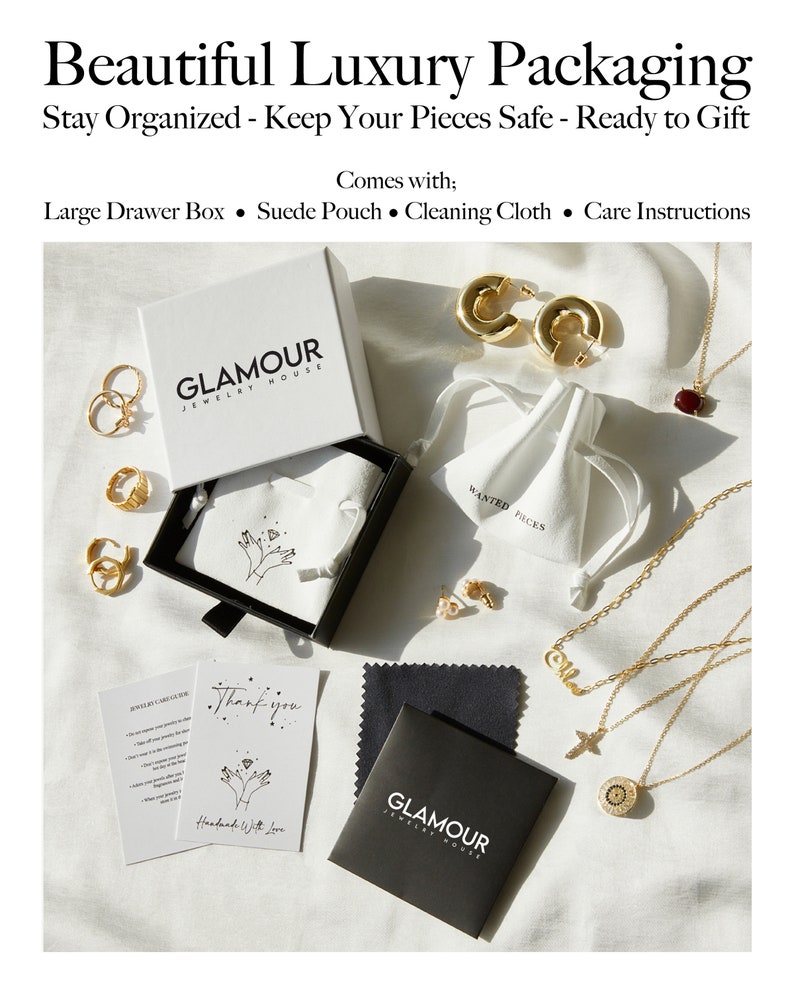May include: A black box with the words "GLAMOUR JEWELRY HOUSE" on it. The box is open and contains a white pouch with the words "WANTED PIECES" on it. There are also several gold necklaces, earrings, and rings in the image. The image also includes a black cleaning cloth with the words "GLAMOUR JEWELRY HOUSE" on it and a card that says "Thank you. Handmade with love."