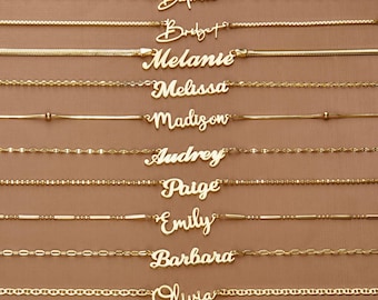 Puede incluir: Diez collares dorados dispuestos horizontalmente, cada uno con un nombre diferente en letra cursiva: Daphne, Bridget, Melanie, Melissa, Madison, Audrey, Paige, Emily, Barbara y Olivia. Cada collar presenta un estilo de cadena único.