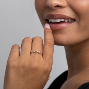 K&ouml;nnte beinhalten: Ein goldener Kettenring mit kleinen Diamanten, die in die Glieder eingefasst sind. Der Ring wird am Finger einer Person getragen.