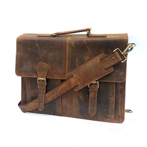May include: A brown leather briefcase with a shoulder strap and two buckles. The bag has a distressed look and is made of high-quality leather.
