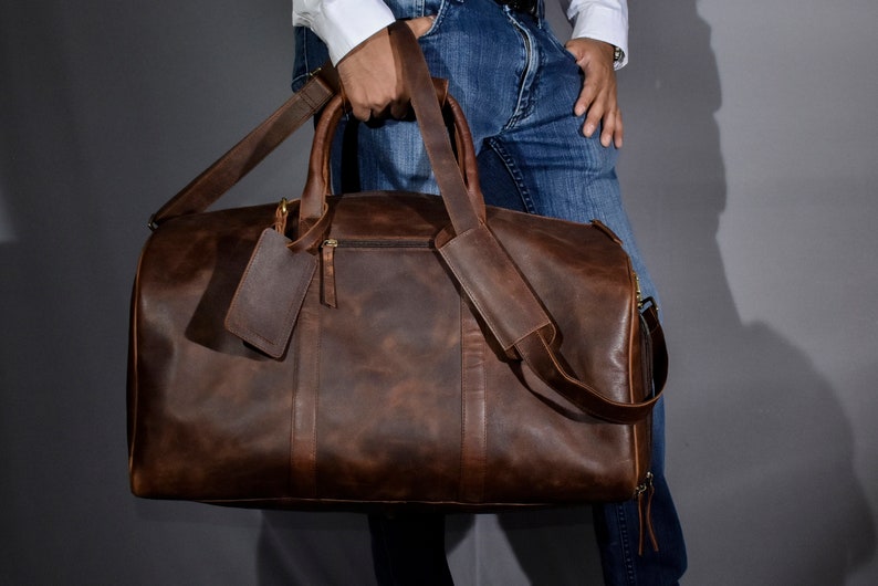 Leather duffel bag for men is a must have for weekend getaway or gym. This leather weekender bag comes with separate shoe compartment to keep used shoes or clothes. The duffle bag has a small zipper pocket on the outside and a trolley sleeve at back.