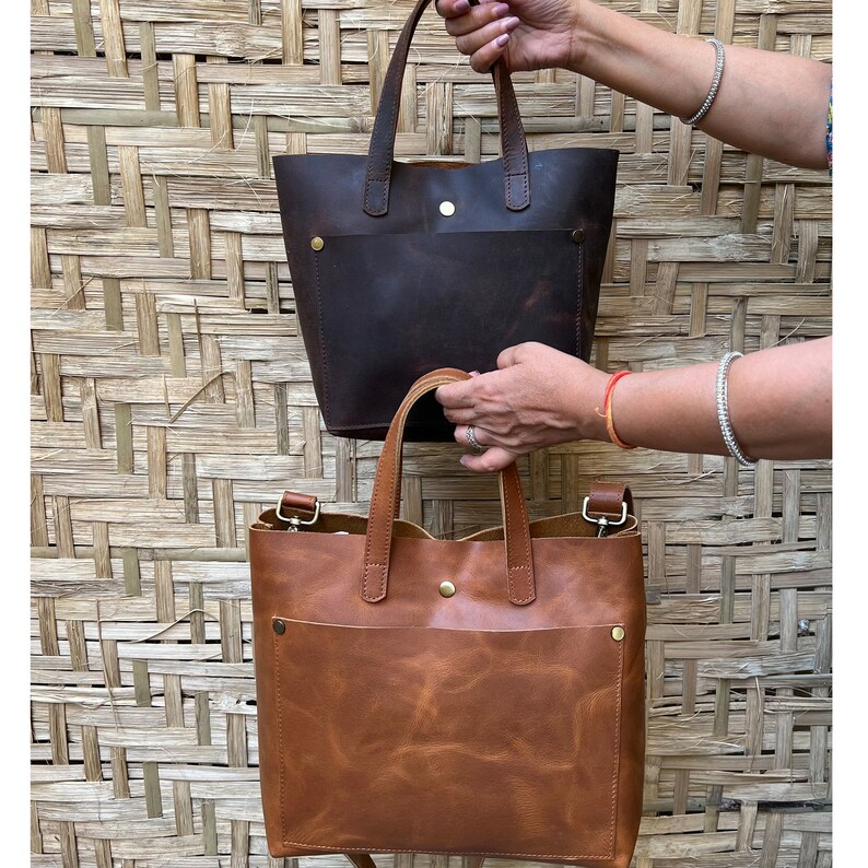 The small leather tote comes in three colours, chocolate brown, cognac and sable black. The bags are made from full grain genuine leather and are handmade. They are made by craftswomen. Each leather skin or hide is handpicked by us to control quality