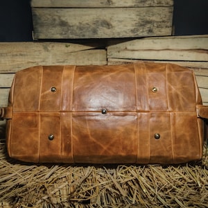 Pu&ograve; includere: Una borsa da viaggio in pelle marrone con dettagli in metallo. La borsa ha un aspetto vissuto ed &egrave; realizzata in pelle di alta qualit&agrave;.