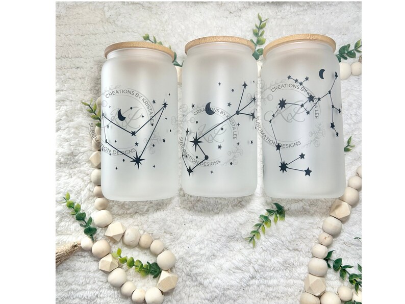 May include: Three frosted glass jars with bamboo lids, each featuring a constellation design with a crescent moon and stars. The jars are labelled "CREATIONS BY KRISTA LEE" and "SUBLIMATION DESIGNS".