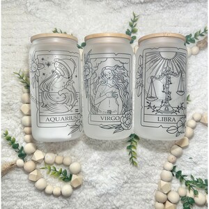 May include: Three frosted glass jars with bamboo lids and black and white zodiac signs. The jars are labelled "Aquarius", "Virgo", and "Libra".
