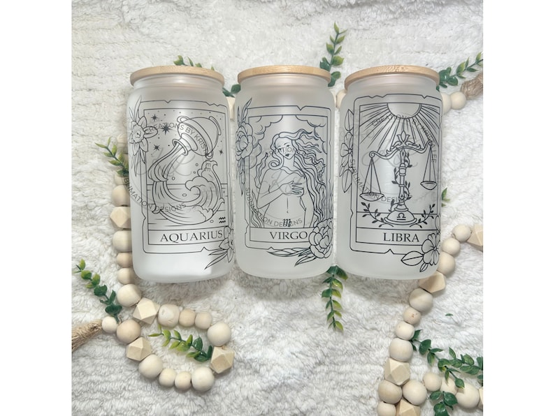 May include: Three frosted glass jars with bamboo lids and black and white zodiac signs. The jars are labelled "Aquarius", "Virgo", and "Libra".
