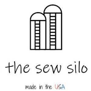 May include: Black and white line art logo featuring two silos with ladders, above the text "- the sew silo -". Below the text is "made in the USA" in a handwritten font.