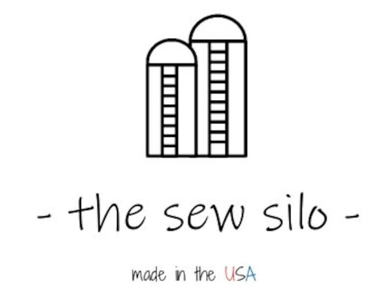 May include: Black and white line art logo featuring two silos with ladders, above the text "- the sew silo -". Below the text is "made in the USA" in a handwritten font.