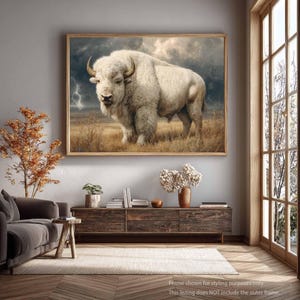 Può includere: Una stampa artistica da parete rettangolare raffigurante un bisonte bianco in piedi in un campo di prateria dorato sotto un cielo scuro e tempestoso con un fulmine visibile. L'opera è esposta in una cornice di legno, mostrando il folto pelo.