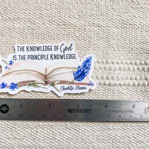 May include: A white sticker with a quote about the knowledge of God by Charlotte Mason. The quote reads "The knowledge of God is the principle knowledge." The sticker features an open book with blue flowers.
