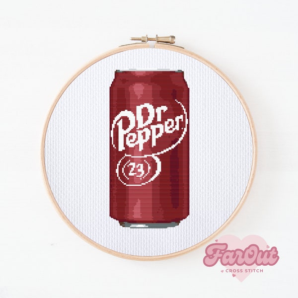 以下が含まれることがあります： 白い布に施されたクロスステッチ刺繍で、マルーン色のソーダ缶が描かれています。缶には白い文字で「Dr Pepper」と書かれ、円形の輪郭の中に数字の「23」が配置されており、木製の円形刺繍枠に収められています。