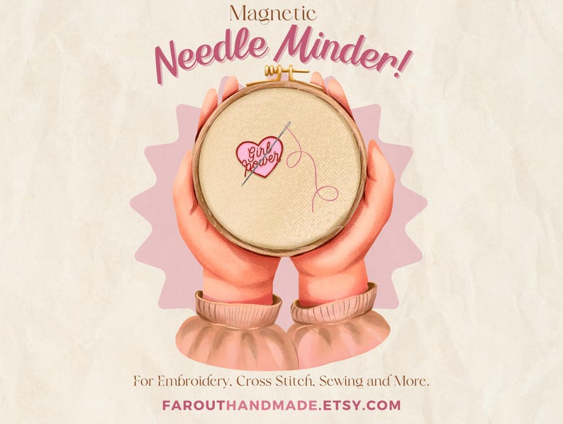 May include: A magnetic needle minder with a pink heart and the text "Girl Power" embroidered on a beige fabric. The needle minder is held by two hands.