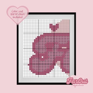 Op de afbeelding: Een kruissteekpatroon van een roze hart met een klein hartje bovenop. Het patroon is in een zwart frame met de tekst "FarOut Cross Stitch" onderaan.
